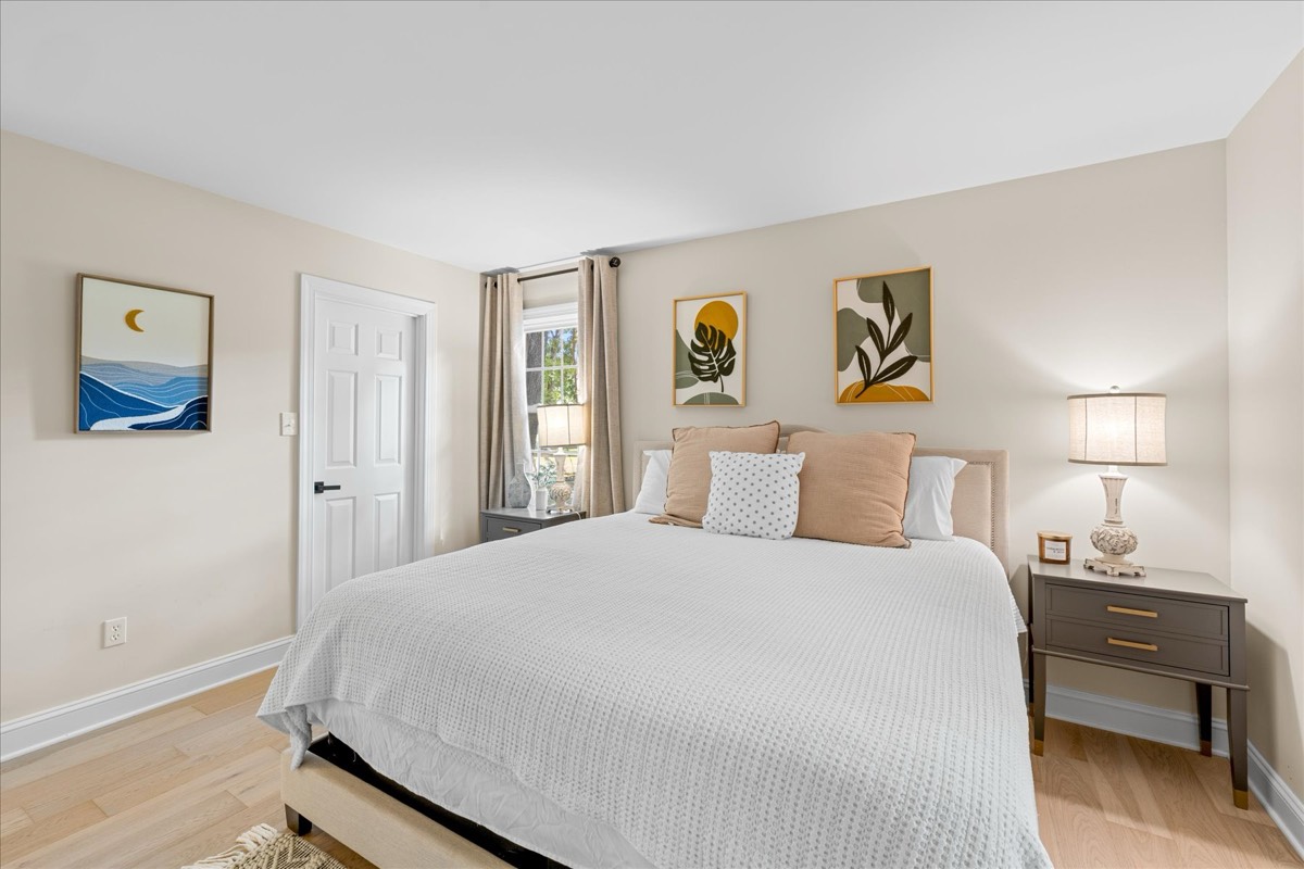 King bed with earth-tone pillows and beach art